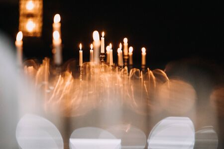 retro candlesticks with burning candles in dark roomの写真素材