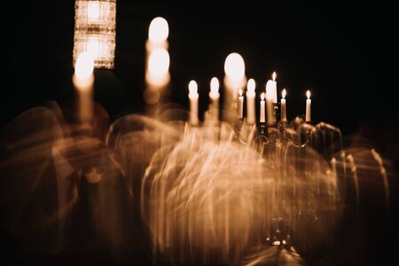 retro candlesticks with burning candles in dark roomの写真素材