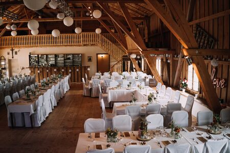 photo of an empty wedding hall with many tablesの写真素材
