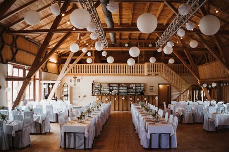 photo of an empty wedding hall with many tablesの写真素材