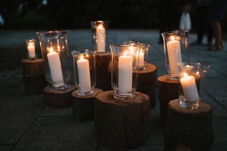 white candles in glass on woodの写真素材
