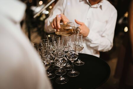 a waiter seving alcohol in glassesの写真素材