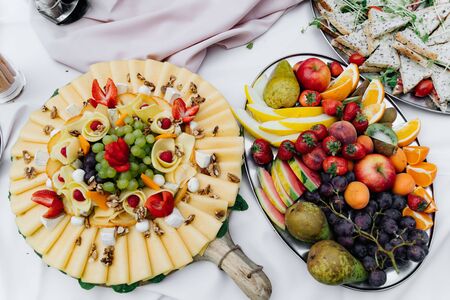 a cheese plate and a fruits plate on a tableの写真素材