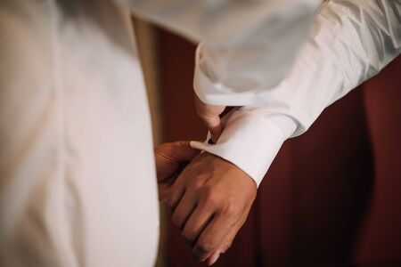 a groom wearing shirt buttonsの写真素材
