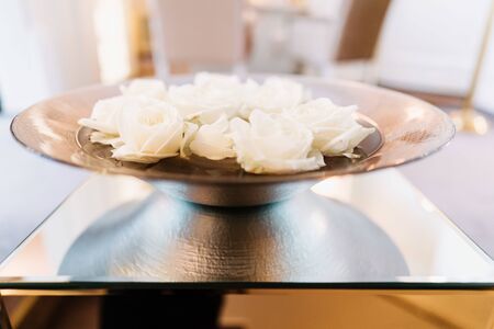 white flowers in a copper bowlの写真素材