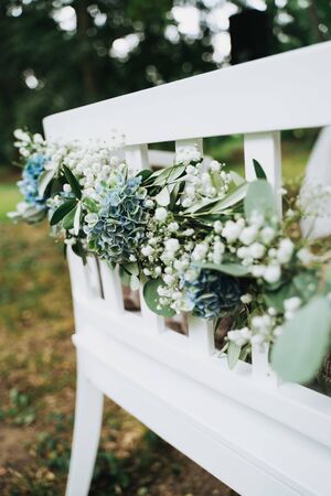 flowers on a white outdoor chair in the gardenの写真素材