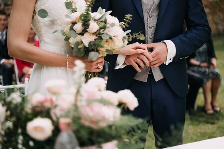 a bride with bouquet and the groom in the gardenの写真素材