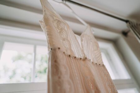 a hanged wedding dress on a windowの写真素材