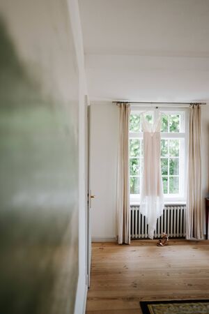a hanged wedding dress on a windowの写真素材