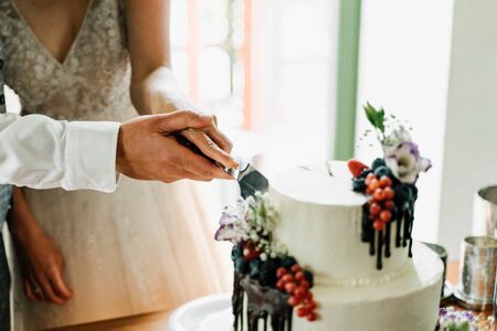 a couple cutting a wedding cakeの写真素材
