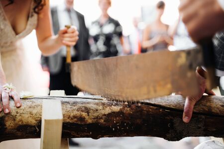 a married couple sawing a trunkの写真素材