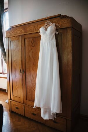 a wedding dress hanged on a closetの写真素材
