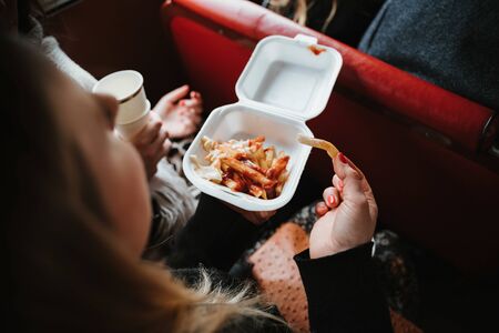 a woman eating fries with ketchupの写真素材