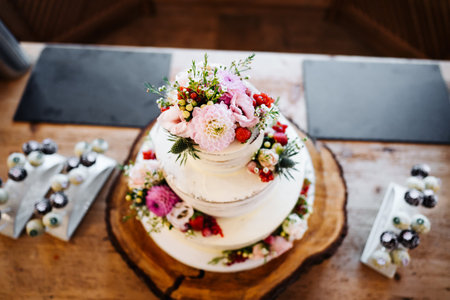 wedding cake with flowers on a tableの写真素材
