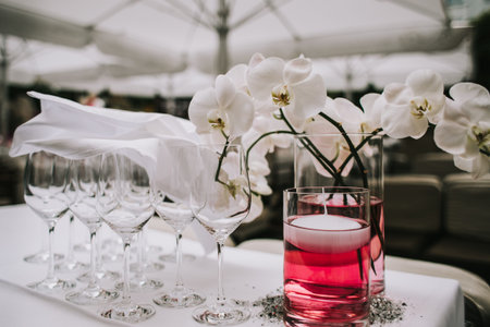 an empty wine glasses next to a flower vase