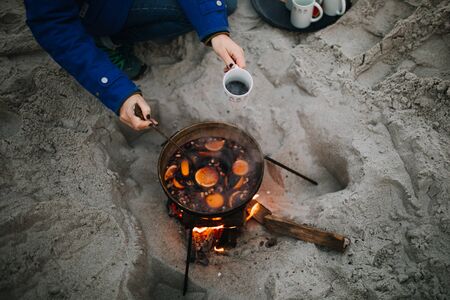 a woman drinking hot wine at the beachの写真素材