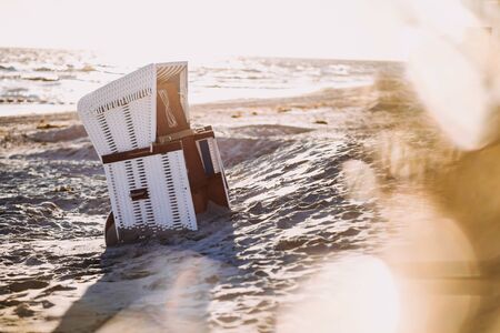 a roofed wicker beach chair at sunsetの写真素材