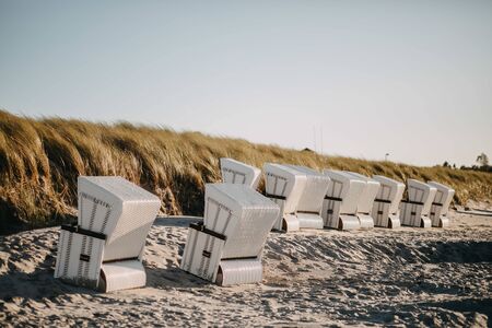 roofed wicker beach chairs at sunsetの写真素材