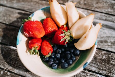 Tasty breakfast - close-up of plate strawberries blueberries and pearsの写真素材