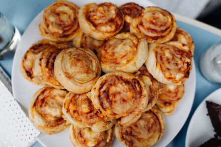 made from puff pastry and filled with mozzarella cheese and tomato sauce served on the rustic porcelain plate. Snack for childern partyの写真素材