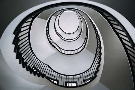 looking deep into long spiral stair case of big buildingの写真素材