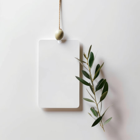 Blank paper tag with olive branch on white background, top viewの素材