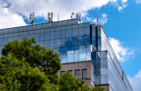 Modern office building, glass surface, trees in the frontの写真素材