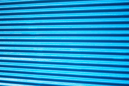 Bright blue corrugated iron sheets door close up for backgroundの写真素材
