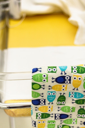 A colorful baby bed with a blanket at a maternity ward. Peaceful composition of a baby bed made of...