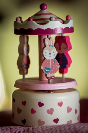 Close-up of a cute music box carousel. The music box is designed for small girls and decorated with pink hearts.の写真素材