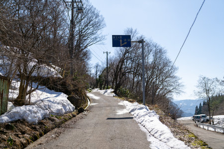 Road in the mountains in winter with snow and blue sky background.の写真素材
