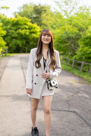 Portrait of thai adult beautiful girl white coat relax and smileの写真素材