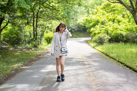 Beautiful asian woman walking on the road in the park.の写真素材