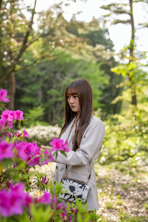 Beautiful asian woman in the park with rhododendron flowersの写真素材
