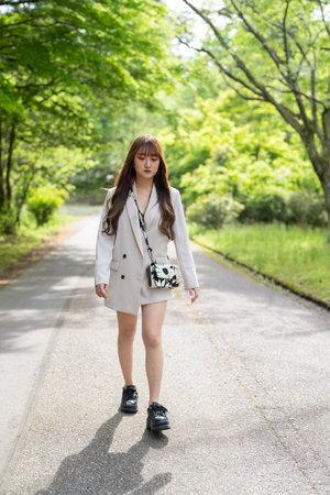 Beautiful asian woman walking on a road in the park.の写真素材