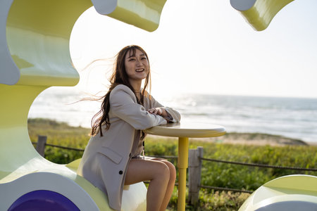 Beautiful young asian woman sitting on the beach chair at the seasideの写真素材