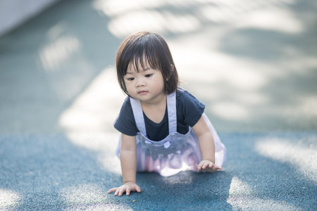A one-year-old Chinese Malaysian girl playing on the children's playground equipment at KLCC Park in Kuala Lumpur City Centre, Malaysia.の写真素材