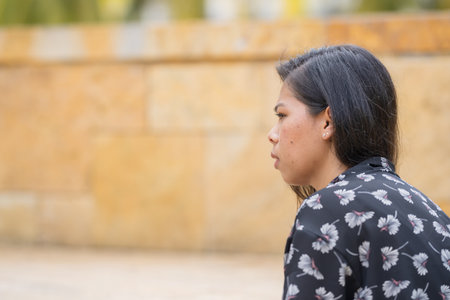 A 30-something Indian Malaysian woman in a historic cobblestone park in City Centre, Kuala Lumpur,...