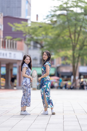 Two women in traditional Chinese clothing enjoying timeの写真素材