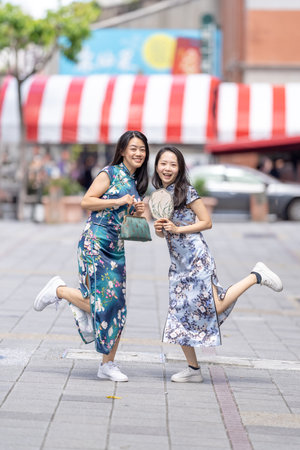 Two women in traditional Chinese clothing enjoying timeの写真素材