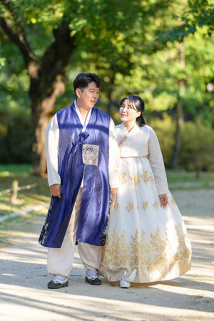 A Korean couple, a man in his 30s and a woman in her 20s, are spending time together in a historic park in Seoul, South Korea.の写真素材
