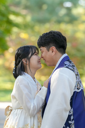 A Korean couple, a man in his 30s and a woman in her 20s, are spending time together in a historic park in Seoul, South Korea.の写真素材