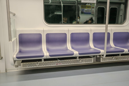 Train with a sign on the door that says "No Smoking". There are four blue seats on the trainのeditorial素材