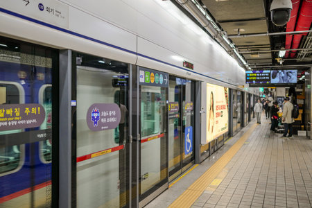 Train station with a sign that says "your train". There are people walking around the stationのeditorial素材