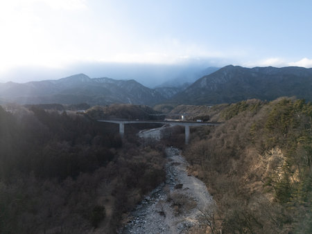 Aerial photograph of the countryside, including rice and private houses, including snow-covered Mt. Senjogatake and Mt. Kiso-Komagatake in Komagane City, Nagano Prefecture, Japan in winter.の写真素材