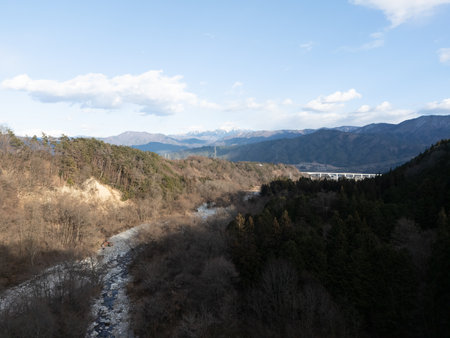 Aerial photograph of the countryside, including rice and private houses, including snow-covered Mt. Senjogatake and Mt. Kiso-Komagatake in Komagane City, Nagano Prefecture, Japan in winter.の写真素材