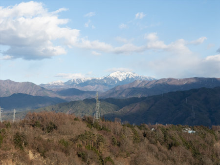 Aerial photograph of the countryside, including snow-covered Mt. Senjogatake and Mt. Kiso-Komagatake in Komagane City, Nagano Prefecture, Japan in winter.の写真素材