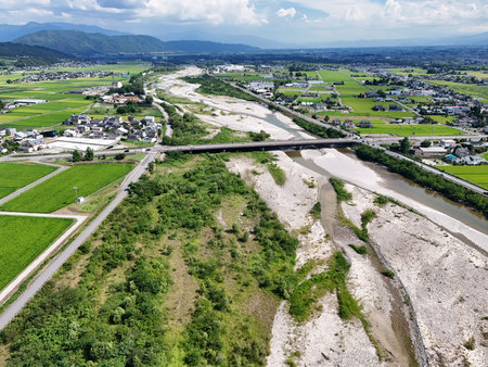 A view of a river with a bridge over it and a town in the background.の写真素材
