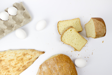 Top view of assortment of different kind of cereal bakery: bread, croissants, buns isolated on white woodden background with copy spaceの写真素材