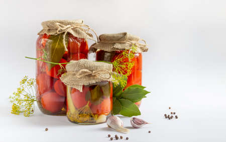 Glass jars with homemade pickled tomatoes, sealed with metal lidの写真素材